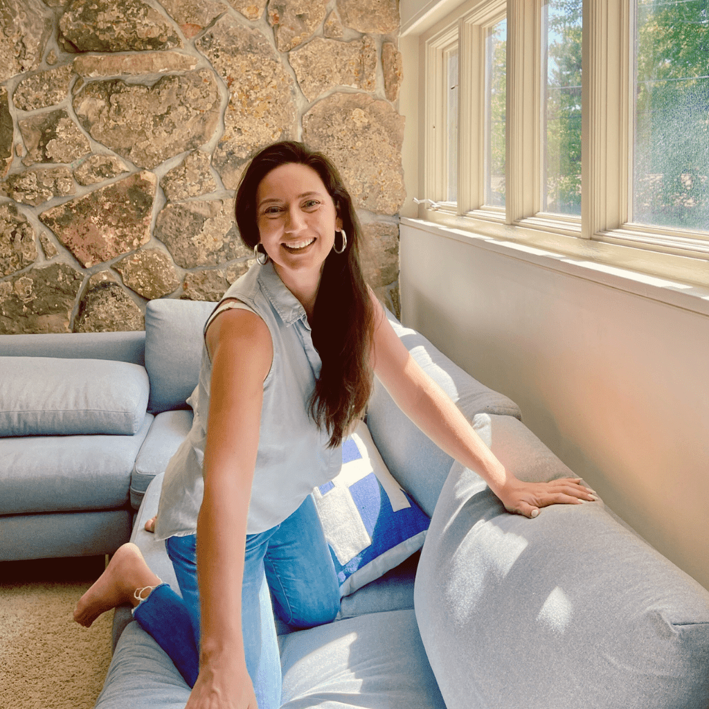 Libby Bryant, founder of Coaching Club on sofa smiling at camera